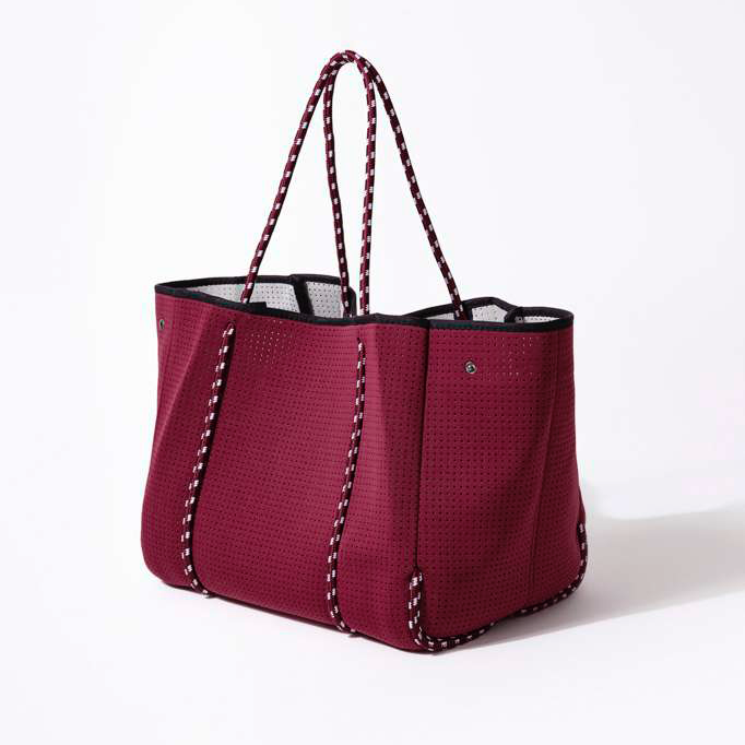 Red tote bag with black accents on a white background