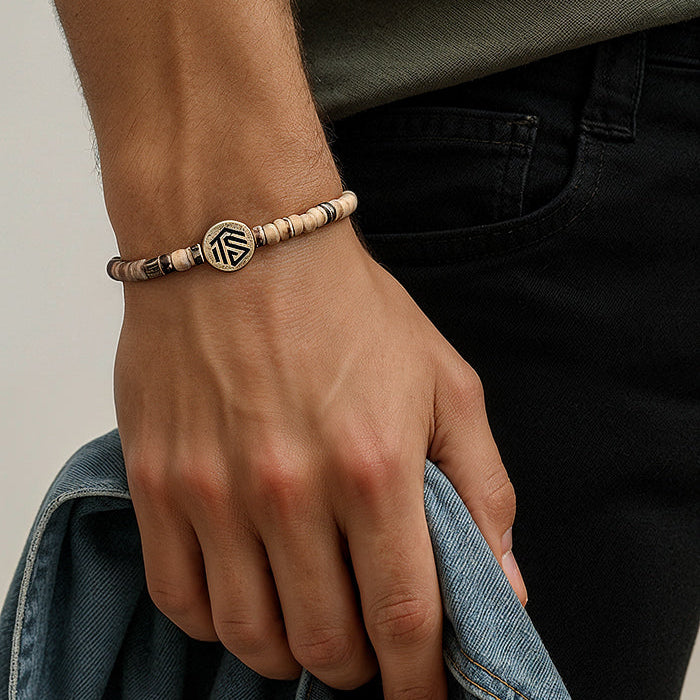 Hand wearing a bracelet with a neutral background