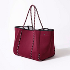 Red tote bag with black accents on a white background