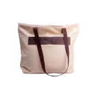 Beige tote bag with brown straps on a white background
