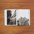 Open spread: a black-and-white slot canyon with sweeping sandstone walls beside two zebras pressed together