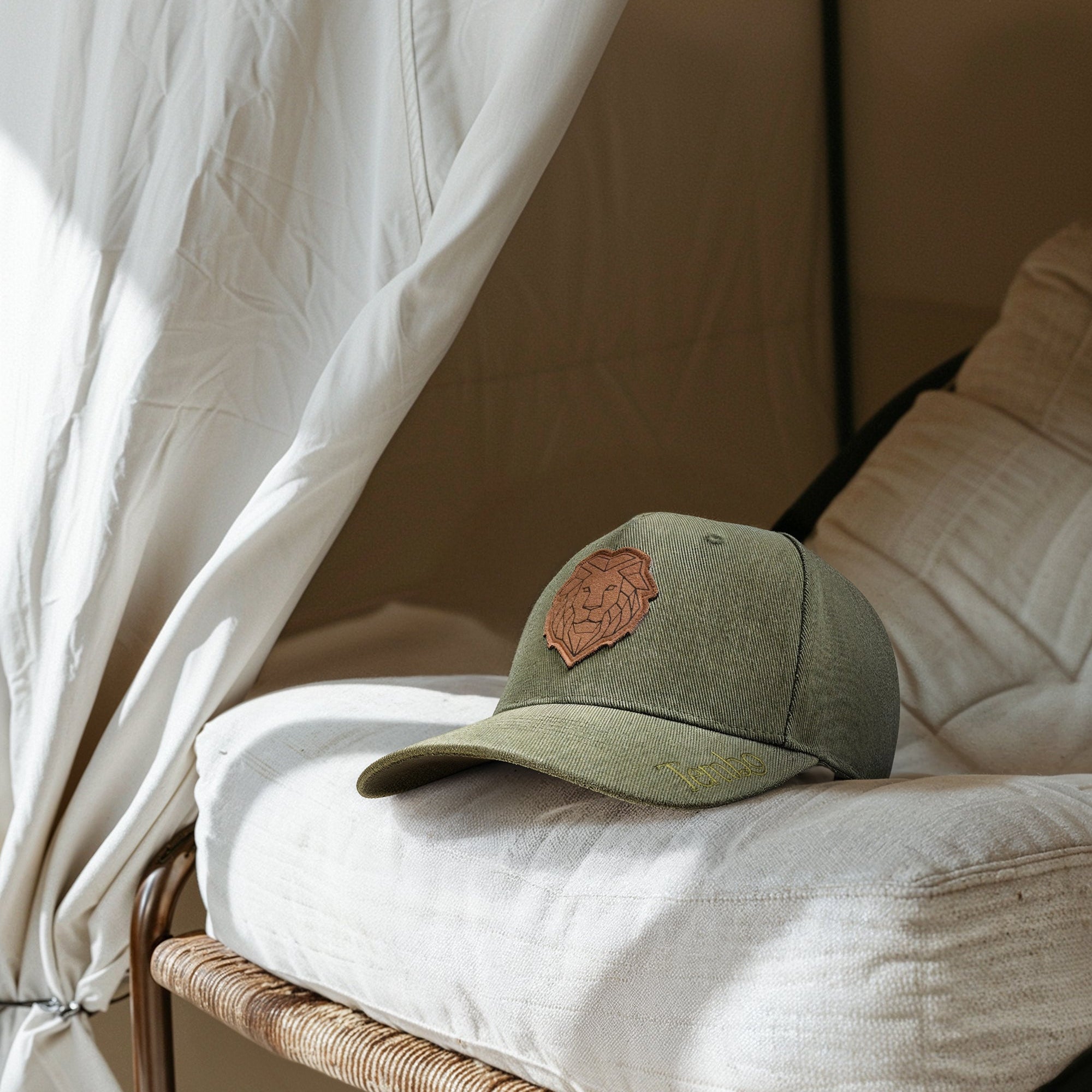 Green cap with a brown patch on a white cushion