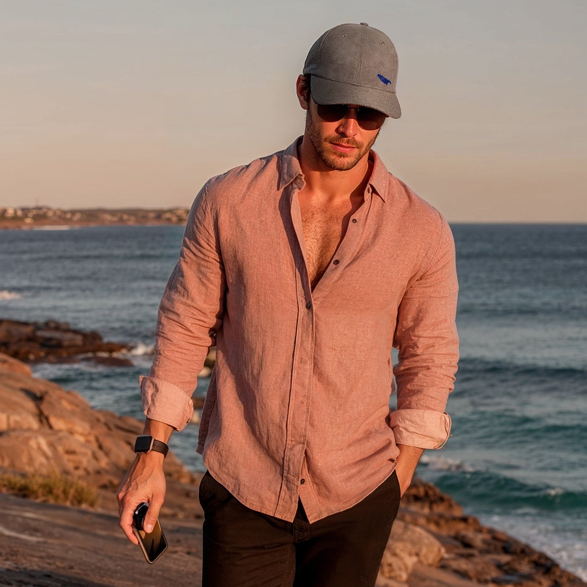 Man walking along a rocky coastal path with ocean in the background