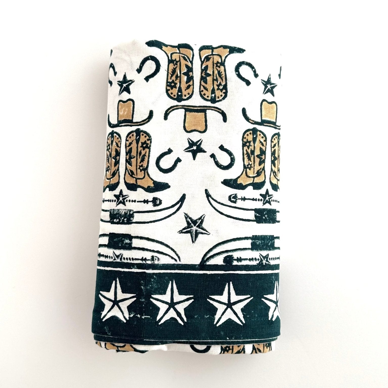 Folded towel with cowboy boot and star pattern on a white background