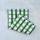 Two green and white checkered towels on a light gray background