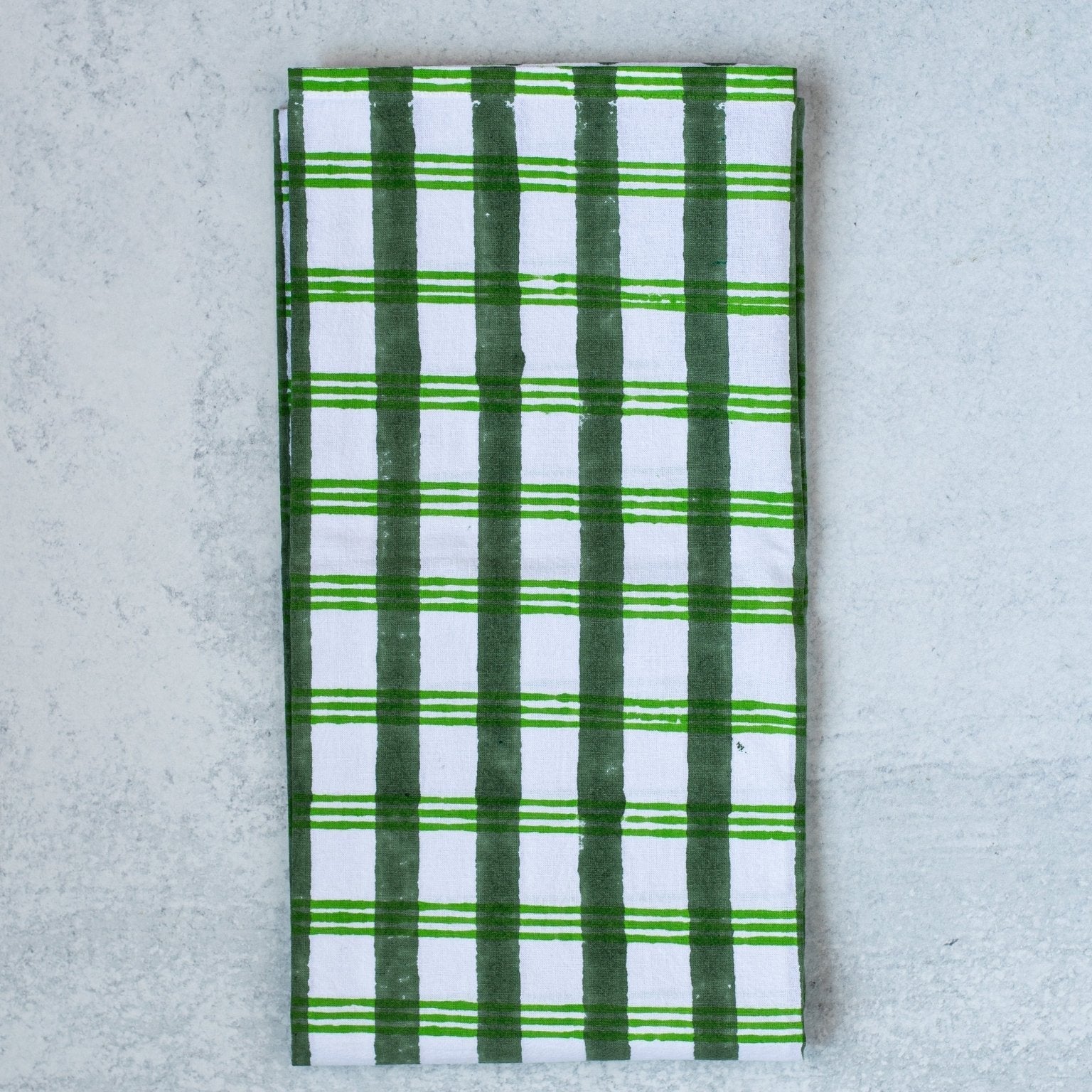 Green and white checkered towel on a gray surface